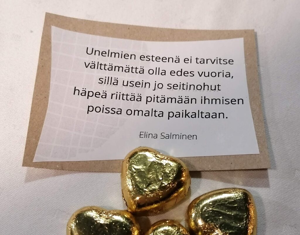 Pöydällä mietelause ja sydänkonvehteja